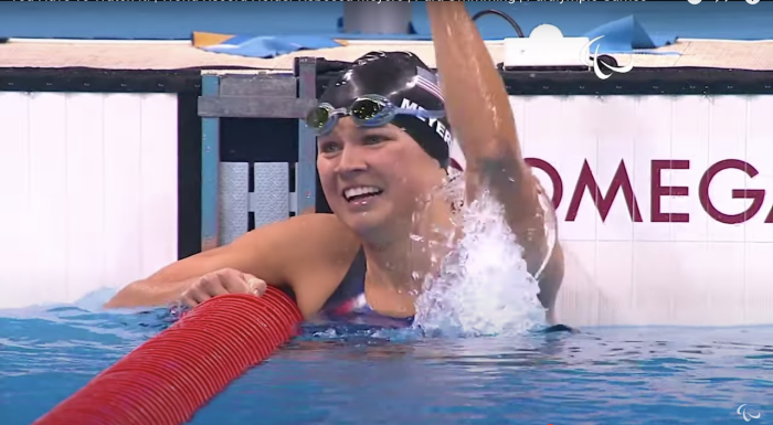 Deaf-blind Paralympian Becca Meyers celebrates in the water at a swimming competition. 