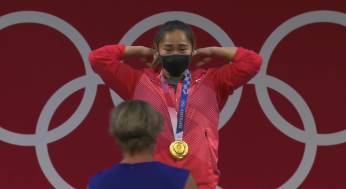 Hidilyn Diaz puts on a gold medal after winning the Philippines' first-ever Olympic gold medal during the Tokyo Olympics on July 26, 2021.