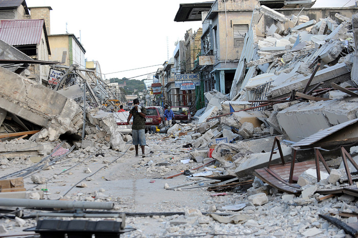 A man covers his face as he walks amid the rubble of a destroyed building in Port-au-Prince on January 14, 2010, following the devastating earthquake that rocked Haiti on January 12. 