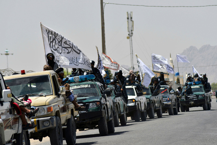 Taliban fighters atop vehicles with Taliban flags parade along a road to celebrate after the US pulled all its troops out of Afghanistan, in Kandahar on September 1, 2021 following the Talibans military takeover of the country. 