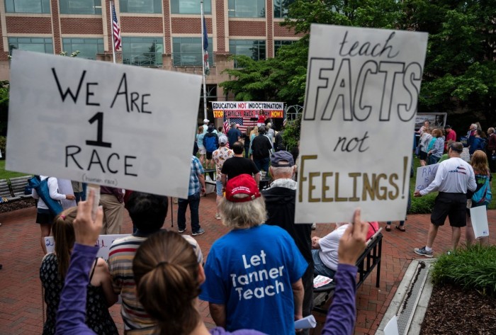 People hold up signs during a rally against 'critical race theory' (CRT) being taught in schools at the Loudoun County Government center in Leesburg, Virginia on June 12, 2021. 'Are you ready to take back our schools?' Republican activist Patti Menders shouted at a rally opposing anti-racism teaching that critics like her say trains white children to see themselves as 'oppressors.' 'Yes!', answered in unison the hundreds of demonstrators gathered this weekend near Washington to fight against 'critical race theory,' the latest battleground of America's ongoing culture wars.