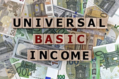 Topview photo on universal basic income theme. Wooden cubes with the inscription 'universal basic income', on the background of dollar and euro bills