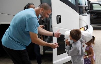 A bus driver helps a child to load his belonging as Afghan refugees arrive at Dulles International Airport on August 27, 2021, in Dulles, Virginia, after being evacuated from Kabul following the Taliban takeover of Afghanistan. 