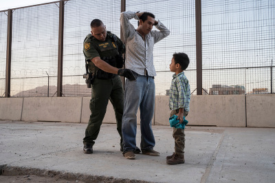 José, 27, with his son José Daniel, 6, is searched by US Customs and Border Protection Agent Frank Pino, May 16, 2019, in El Paso, Texas. Father and son spent a month trekking across Mexico from Guatemala.