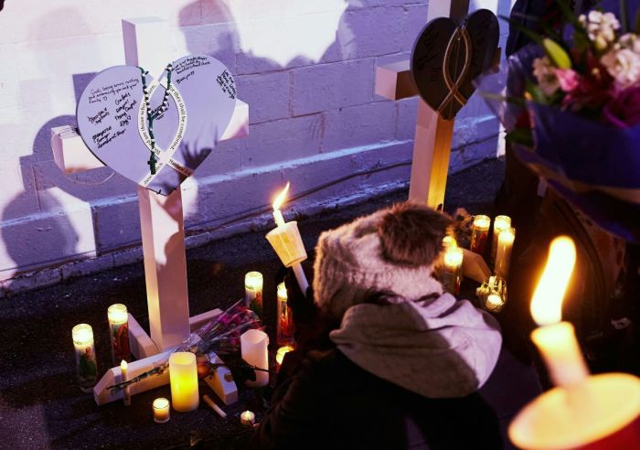 People light candles at a makeshift memorial during a candlelight vigil in Cutler Park in Waukesha, Wisconsin, on Nov. 22, 2021, the day after a vehicle drove through a Christmas parade killing five people. 