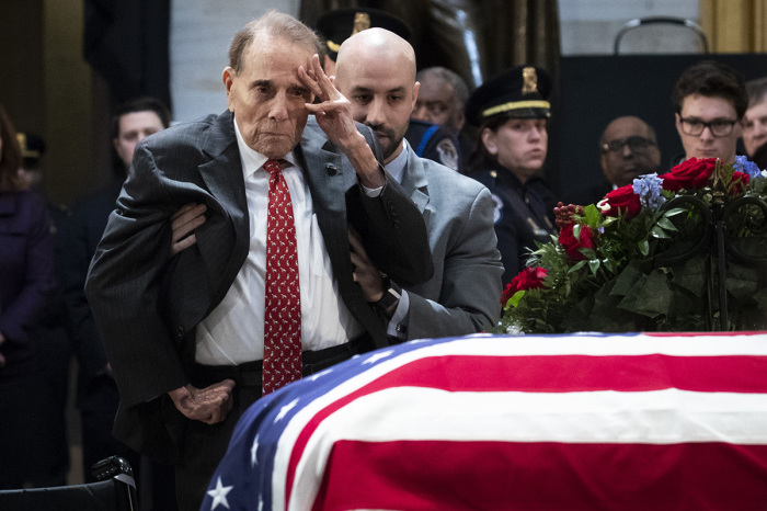 Former Senator Bob Dole stands up and salutes the casket of the late former President George H.W. Bush as he lies in state at the U.S. Capitol, on December 4, 2018 in Washington, D.C. 