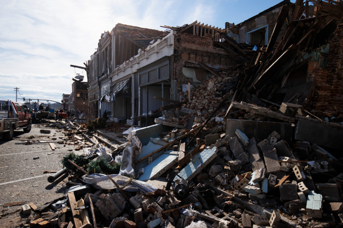 A tornado-damaged building piles into the street on Dec. 11, 2021, in Mayfield, Kentucky. Multiple tornadoes tore through parts of the lower Midwest late on Friday night leaving a large path of destruction and multiple fatalities. 