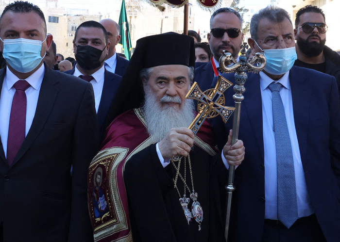 Greek Orthodox Patriarch of Jerusalem Theofilos III (C) arrives at the Church of the Nativity for the Orthodox Christmas celebrations on January 6, 2022, in the biblical West Bank town of Bethlehem, the traditional birthplace of Jesus Christ. 