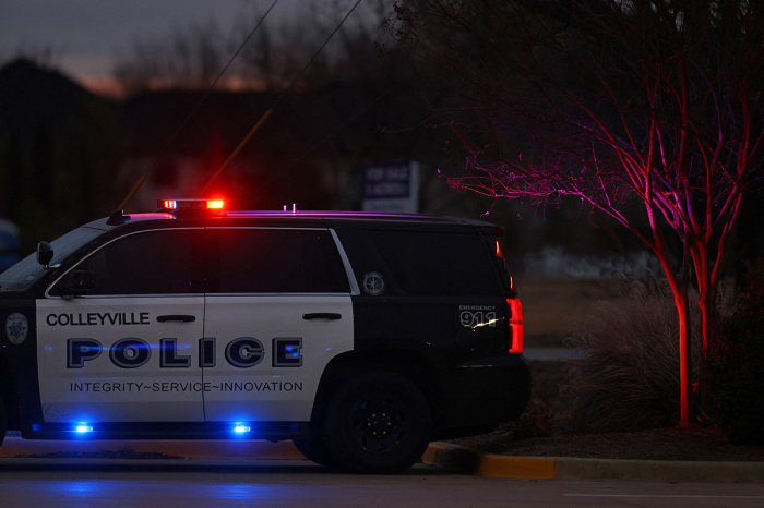 A Police car is seen driving close to the Congregation Beth Israel Synagogue in Colleyville, Texas, some 25 miles (40 kilometers) west of Dallas, on January 15, 2022. - Hostage negotiators were locked in a tense standoff January 15 at the Texas synagogue where a man claiming to be the brother of a convicted terrorist has reportedly taken a rabbi and several others captive, police and media said. One of several hostages being held at a synagogue in Texas has been released, local police said Saturday. 'Shortly after 5 p.m. (2300 GMT), a male hostage was released uninjured,' the Colleyville police department said in a statement.