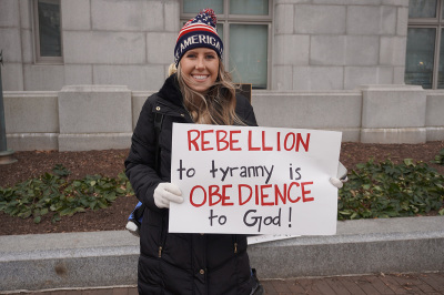 Annabelle Rutledge, the organizer of a protest in opposition to the COVID-19 vaccine mandate in Washington, D.C., stands in front of the John A. Wilson Building, the office of Mayor Muriel Bowser, Jan. 15, 2022.