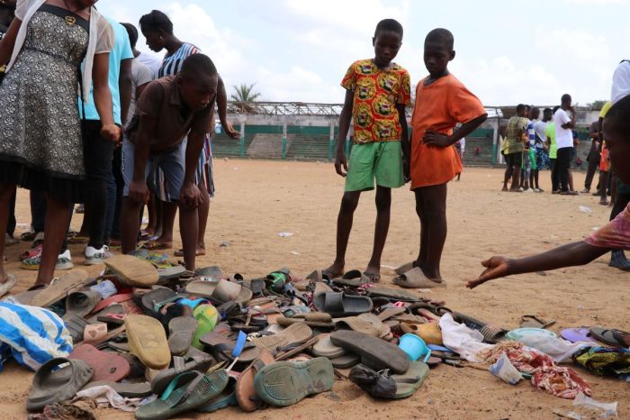 People search through piles of shoes left at a field in Monrovia, on January 20, 2022, where 29 people, including a pregnant woman and 11 children are confirmed dead after a stampede broke out at a Christian crusade on the night of January 19, 2022. 