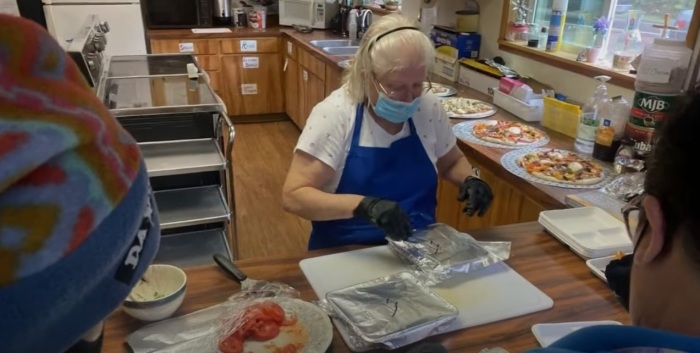 A volunteer helps give food to the needy at St. Timothy’s Episcopal Church of Brookings, Oregon. In January 2022, the church and its diocese filed suit against Brookings city officials over an ordinance restricting their homeless ministry. 