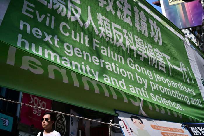 A man walks past banners criticizing the Falun Gong spiritual movement displayed along a pavement in Causeway Bay, a popular shopping district, in Hong Kong on April 25, 2019. A demonstration by thousands of Falun Gong members around Communist Party headquarters in Beijing on April 25, 1999, led to a government crackdown and later the banning of the group which once boasted more than 70 million followers. 