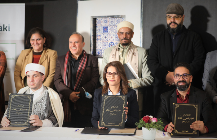 Signatories pose for photos after the signing of the National Charter for Peaceful Coexistence in Tunisia on Jan. 26, 2022. 