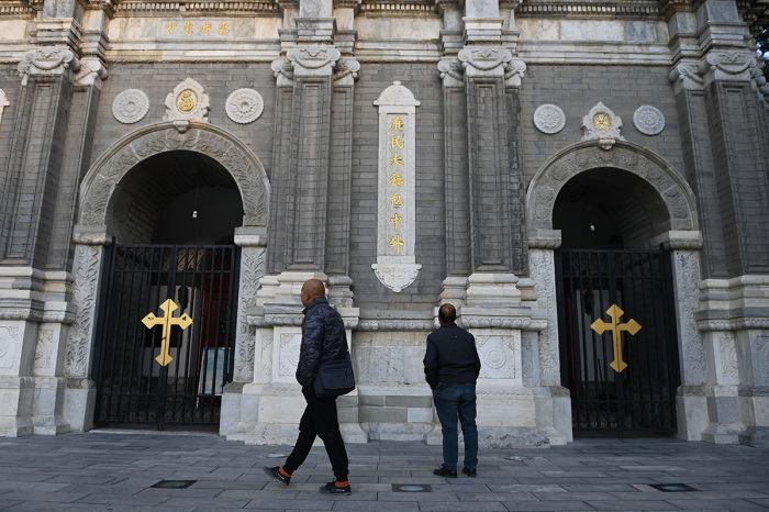 Two men look at St Joseph's Church, also known as Wangfujing Catholic Church, in Beijing on October 22, 2020, the day a secretive 2018 agreement between Beijing and the Vatican was renewed for another two years. 