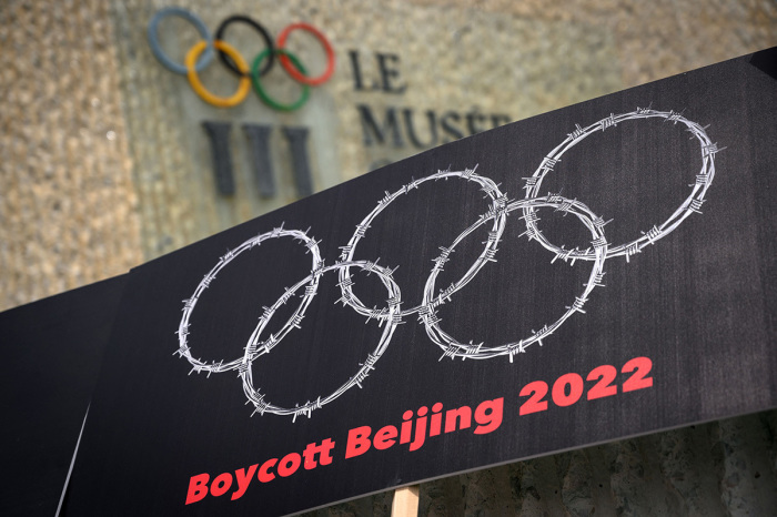 This photograph taken on June 23, 2021, shows a placard representing barber wire shaping and Olympics Rings are seen next to a sign of the Olympics Museum during a protest organised by Tibetan and Uyghur activists against Beijing 2022 Winter Olympics, in Lausanne as some 200 participants took part to the protest. 