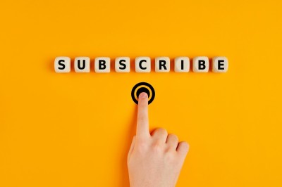 Male hand pressing subscription button with the word subscribe written on wooden blocks. Online registration concept.