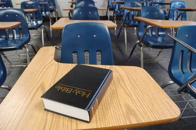 Bible on a school desk in a classroom.