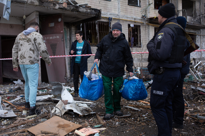 The residents leave their house which got shelled on March 14, 2022 in Obolon district of Kyiv, Ukraine. Russian forces continue to attempt to encircle the Ukrainian capital, although they have faced stiff resistance and logistical challenges since launching a large-scale invasion of Ukraine last month. Russian troops are advancing from the northwest and northeast of the city. (Photo by Anastasia Vlasova/Getty Images)