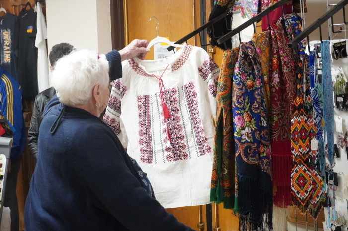 A woman admires a blouse at Saint Andrew Ukrainian Orthodox Cathedral in Colesville, Maryland, at a March 20, 2022, Bazaar fundraiser in which members of the parish and people from the community sold items and clothing to raise money for Ukraine amid the Russian invasion.