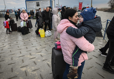 Ukrainian refugees take a ferry to cross the Danube river at the Ukrainian-Romanian border at Isaccea-Orlivka on March 25, 2022.