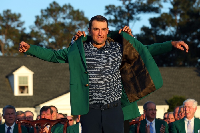 Scottie Scheffler is awarded the Green Jacket by 2021 Masters champion Hideki Matsuyama of Japan during the Green Jacket Ceremony after he won the Masters at Augusta National Golf Club on April 10, 2022, in Augusta, Georgia. 