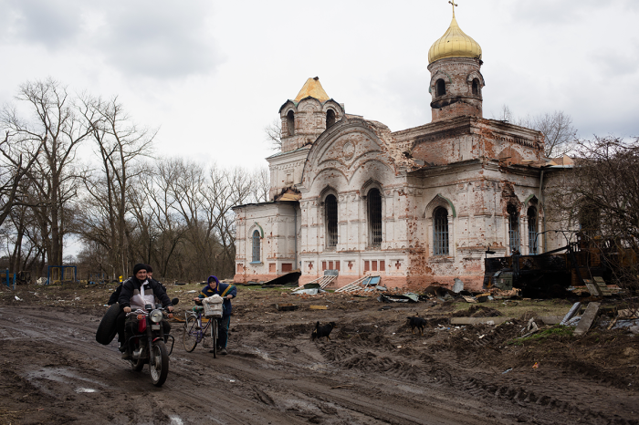 Local residents pass by a destroyed church which served as a military base for Russian soldiers on April 10, 2022, in Lukashivka village, Ukraine. The Russian retreat from Ukrainian towns and cities has revealed scores of civilian deaths and the full extent of devastation since the beginning of the Russian invasion.