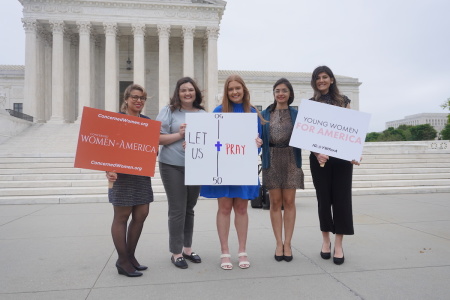 Demonstrators gathered with signs outside the U.S. Supreme Court in Washington, D.C. in support of football coach Joe Kennedy, who lost his job after kneeling on the field pray. Kennedy's case was heard by the high court on Monday, April 25, 2022.