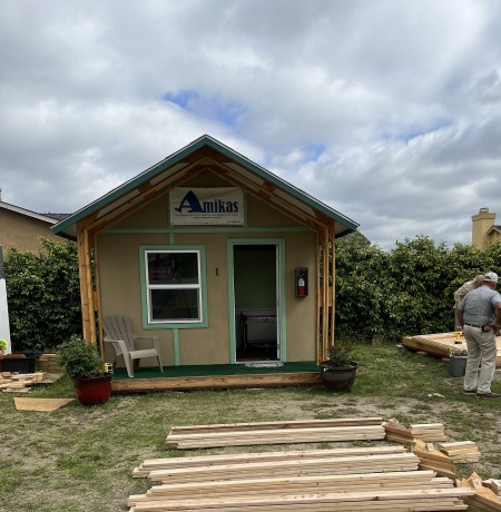 A cabin under construction with a sign on top that reads "Amikas."