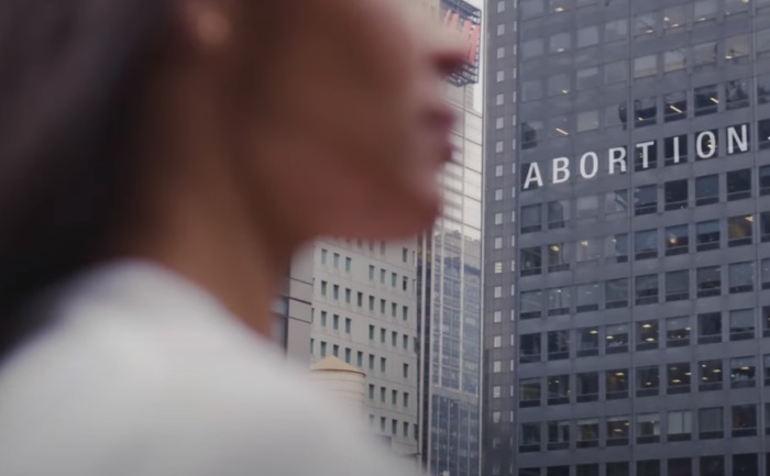 A woman walks past a building highlight the word 'abortion' in 'The Matter of Life' documentary trailer posted on YouTube on March 21, 2022.