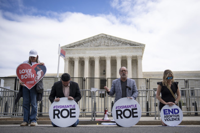 Led by the Rev. Patrick Mahoney (2nd from R), a small group of pro-life activists kneel and pray in front of the U.S. Supreme Court on May 11, 2022, in Washington, D.C.