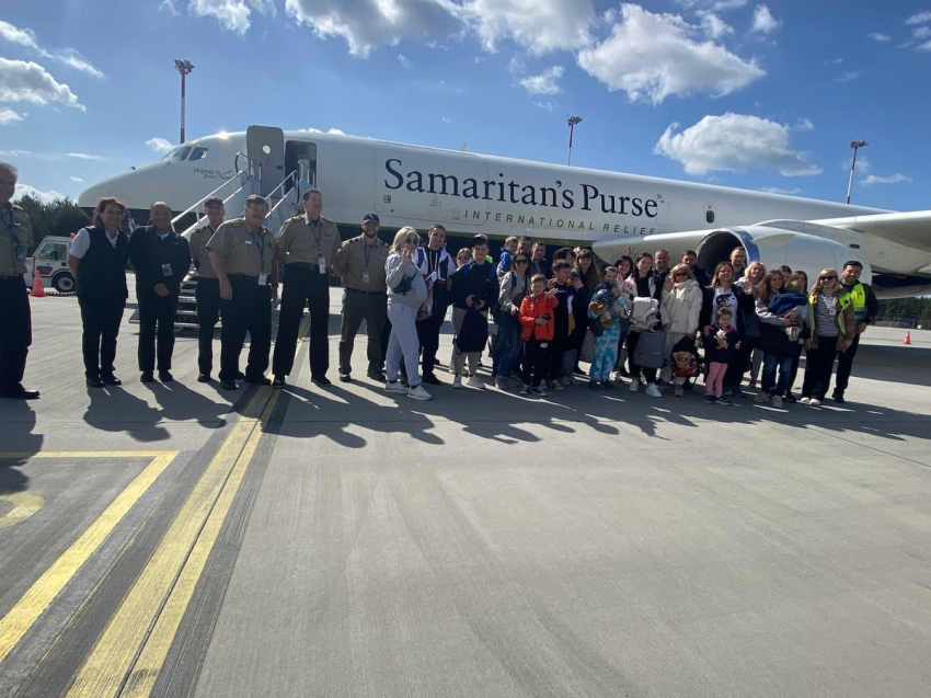 Ukrainian refugees pose for a picture in front of DC-8, the Samaritan's Purse plane that transported them from Poland to Canada.
