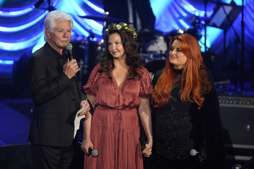 (L-R) Larry Strickland, Ashley Judd, and Wynonna Judd speak onstage for Naomi Judd: "A River Of Time" celebration on May 15, 2022, in Nashville, Tennessee.