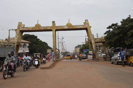 Motor bike taxis drive past Kofar Aliyu Jedo, a city gate in ancient Sokoto, northwest Nigeria on September 21, 2021. - On one of the routes taken by the camel caravans during the trans-Saharan trade era, the town of Sokoto is still, two centuries later, a major commercial crossroads for millions of people living in the far northwest of the country. Nigeria.