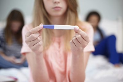 A woman looks at a pregancy test