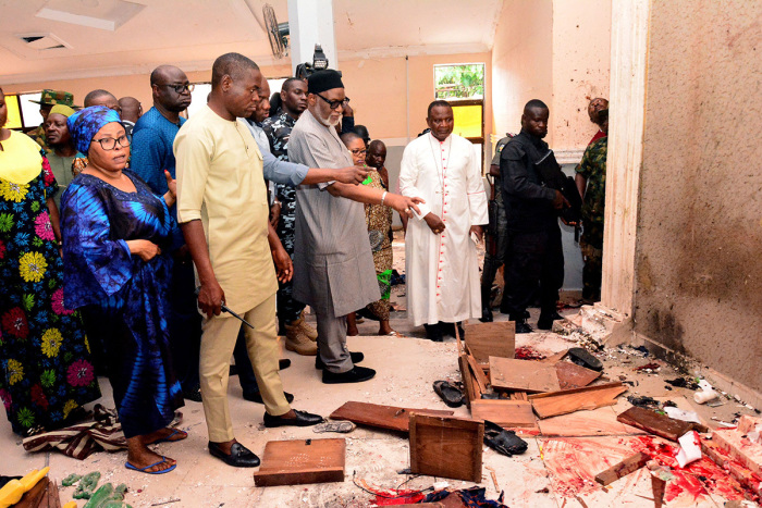 Ondo State governor Rotimi Akeredolu (3rd L) points to blood the stained floor after an attack by gunmen at St. Francis Catholic Church in Owo town, southwest Nigeria on June 5, 2022. - Gunmen with explosives stormed a Catholic church and opened fire in southwest Nigeria on June 5, killing 'many' worshipers and wounding others, the government and police said. The violence at St. Francis Catholic Church in Owo town in Ondo State erupted during the morning service in a rare attack in the southwest of Nigeria, where jihadists and criminal gangs operate in other regions. 