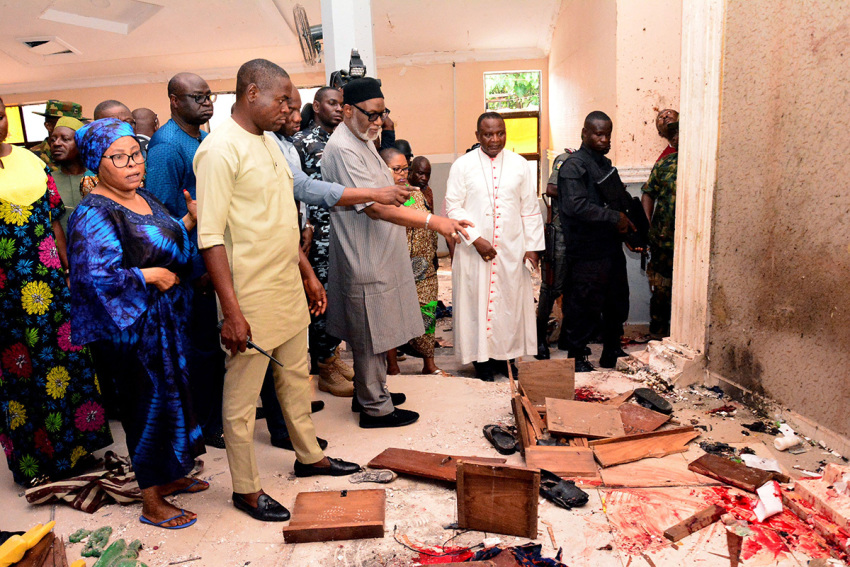 Ondo State governor Rotimi Akeredolu (3rd L) points to blood the stained floor after an attack by gunmen at St. Francis Catholic Church in Owo town, southwest Nigeria on June 5, 2022. - Gunmen with explosives stormed a Catholic church and opened fire in southwest Nigeria on June 5, killing "many" worshipers and wounding others, the government and police said. The violence at St. Francis Catholic Church in Owo town in Ondo State erupted during the morning service in a rare attack in the southwest of Nigeria, where jihadists and criminal gangs operate in other regions. 