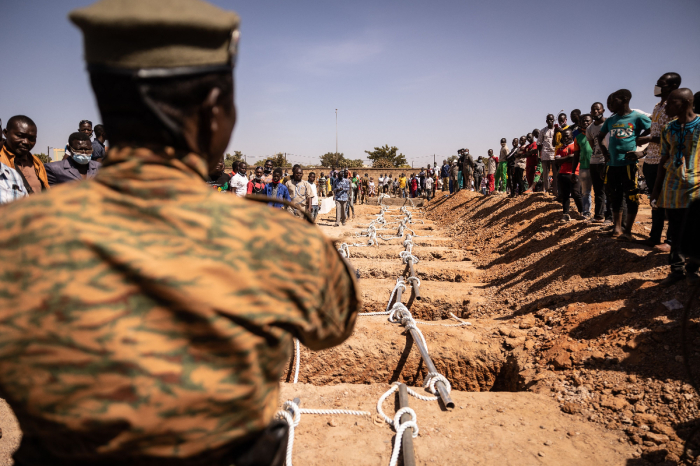 A military official stands by the graves during the burial in the military section at Gounghin Cemetery in Ouagadougou, Burkina Faso, on November 23, 2021 prepared for Burkinabe soldiers killed in the attack on a gendarmerie camp at Inata on November 14, 2021. 