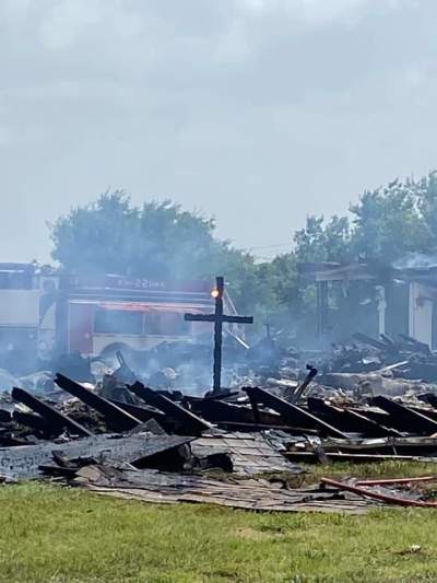 A wooden cross stands among the ruins of a fire that destroyed the Balsora Baptist Church in Wise County, Texas.