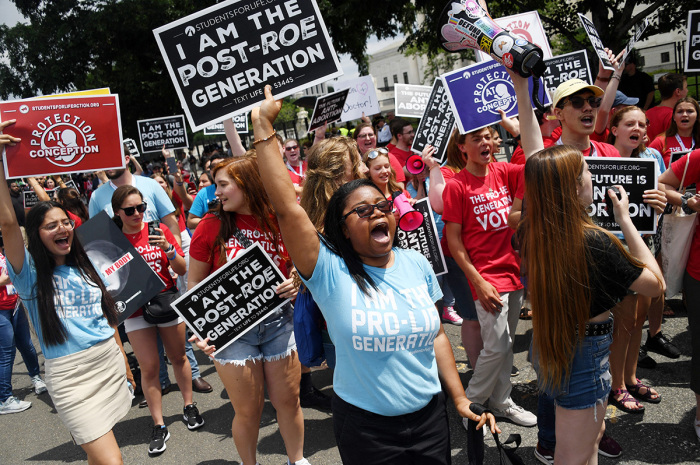 Pro-life campaigners celebrate near the U.S. Supreme Court in the streets of Washington, D.C., on June 24, 2022. - The U.S. Supreme Court on Friday reversed legalized abortion nationwide in one of the most divisive and bitterly fought issues in American political life. The court overturned the landmark 1973 Roe v. Wade decision and said individual states can permit or restrict the procedure themselves. 