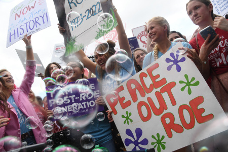 Anti-abortion campaigners celebrate outside the U.S. Supreme Court in Washington, D.C., on June 24, 2022. - The U.S. Supreme Court on Friday ended legalized abortion nationwide in one of the most divisive and bitterly fought issues in American political life. The court overturned the landmark 1973 Roe v. Wade decision and said individual states can permit or restrict the procedure themselves.