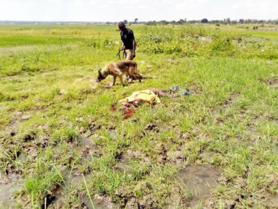 Police dog and officer with body of Simolya Latifu, killed near Molu village, eastern Uganda on July 3, 2022. 