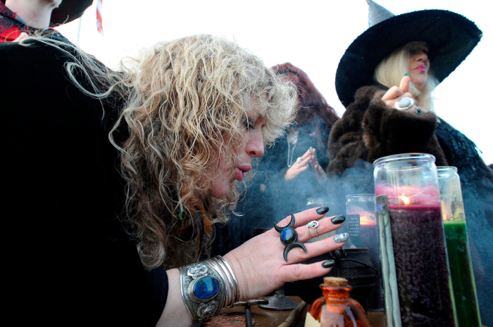 Salem Witch Sandra Wright blows in the fumes from the incense during the Salem Witches' Magic Circle at Salem Common on Halloween in Salem, MA on October 31, 2018. The ceremony involving local and visiting witches celebrates loved ones that have crossed over into the spirit world. The witches believe that on Halloween, the veil between the living and the dead is at its thinnest and connections can be made to those being mourned or missed. 