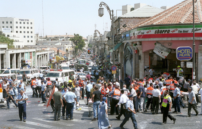 Israeli medics and volunteers treat the injured at the site of a Palestinian suicide bombing on August 9, 2001, in Jerusalem, Israel. At least 18 people, including six children, were killed in the explosion, and more than 80 others were injured in the blast at a Sbarro pizzeria. The bombing occurred at lunchtime at the busy intersection of Jaffa and St. George's streets in the heart of downtown Jerusalem. (Photo by Getty Images)