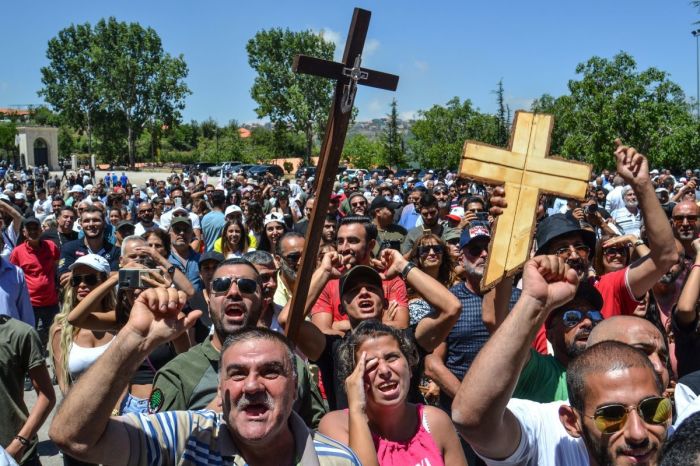 Protesters raise crosses and chant slogans as they gather during a rally at the current patriarch's summer residence in Diman in north Lebanon on July 24, 2022, to condemn the detention and questioning of a Maronite archbishop over crossing into Israel.
