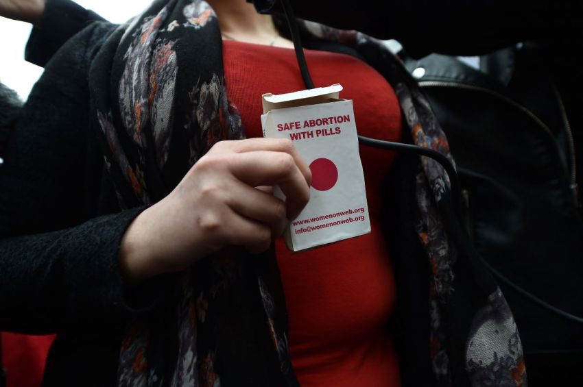 An unindentified woman displays an abortion pill packet after taking one of the pills as abortion rights campaign group ROSA, Reproductive Rights Against Oppression, Sexism and Austerity distribute abortion pills from a touring bus on May 31, 2018 in Belfast, Northern Ireland.