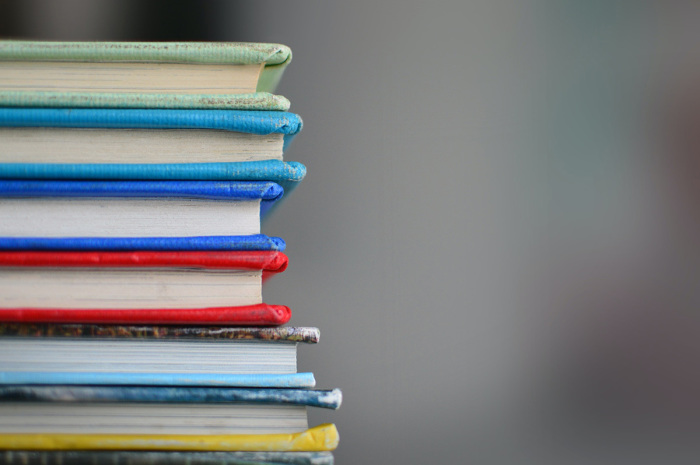 A pile of colorful books sit in a stack.