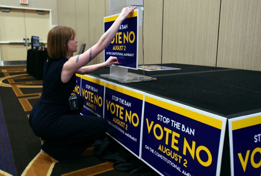 Field organizer Jae Grey places signs on the podium before the pro-choice Kansas for Constitutional Freedom primary election watch party in Overland Park, Kansas, August 2, 2022. - Voters headed to the polls in the Midwestern US state of Kansas Tuesday to weigh in on the first major ballot on abortion since the Supreme Court ended the national right to the procedure in June.