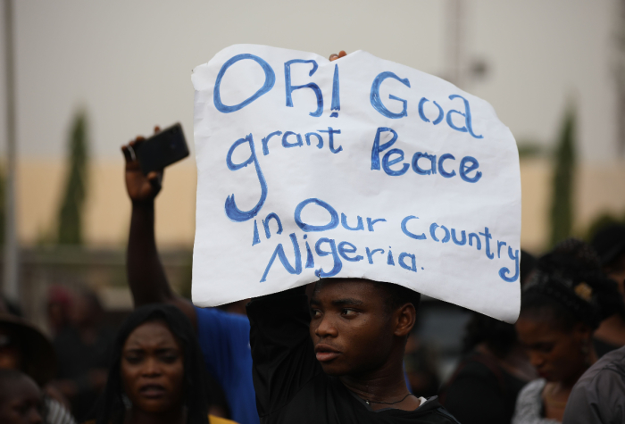 Christians hold signs as they march on the streets of Abuja during a prayer and penance for peace and security in Nigeria in Abuja on March 1, 2020. 