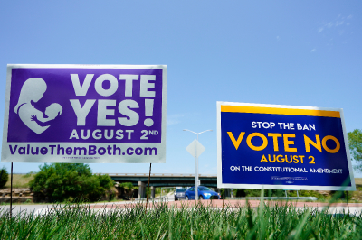 Signs in favor and against the Kansas constitutional amendment on abortion are displayed outside Kansas 10 highway on Aug. 1, 2022 in Lenexa, Kansas. 